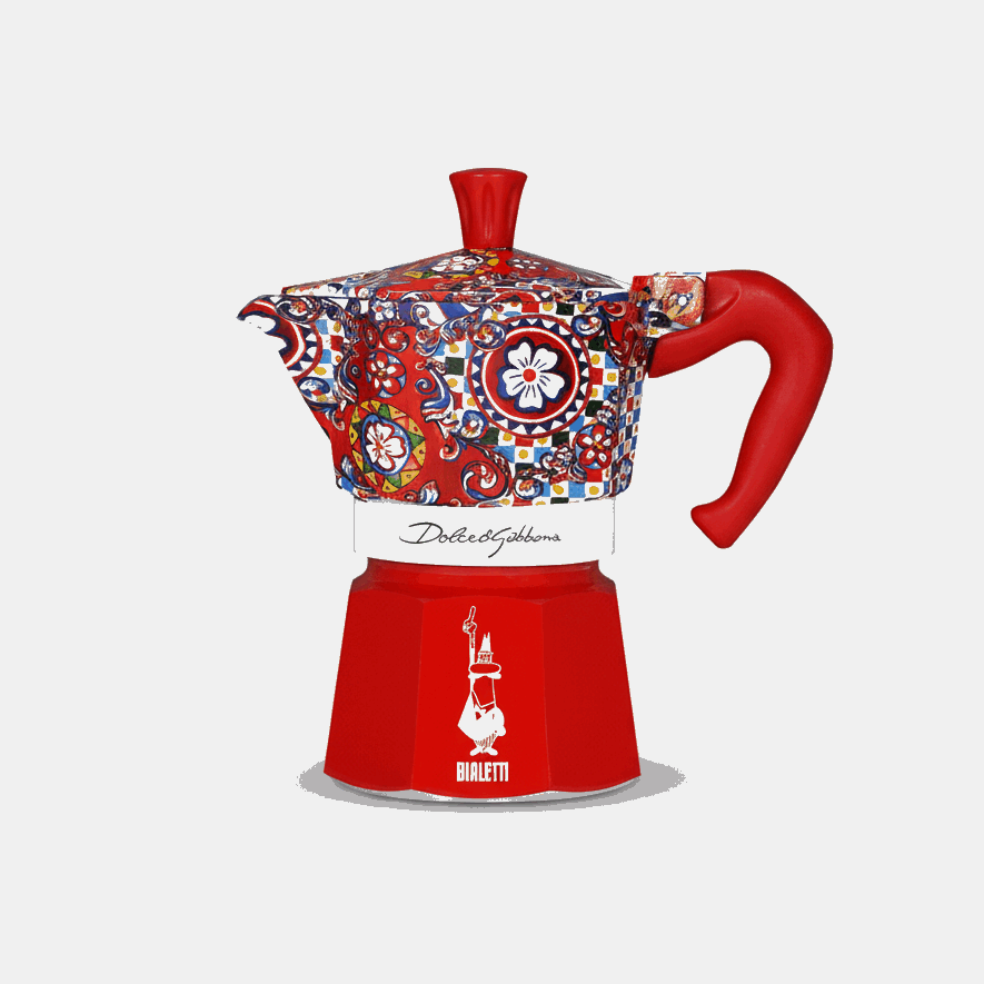 Decorative coffee maker with colorful pattern and red handle on a white background