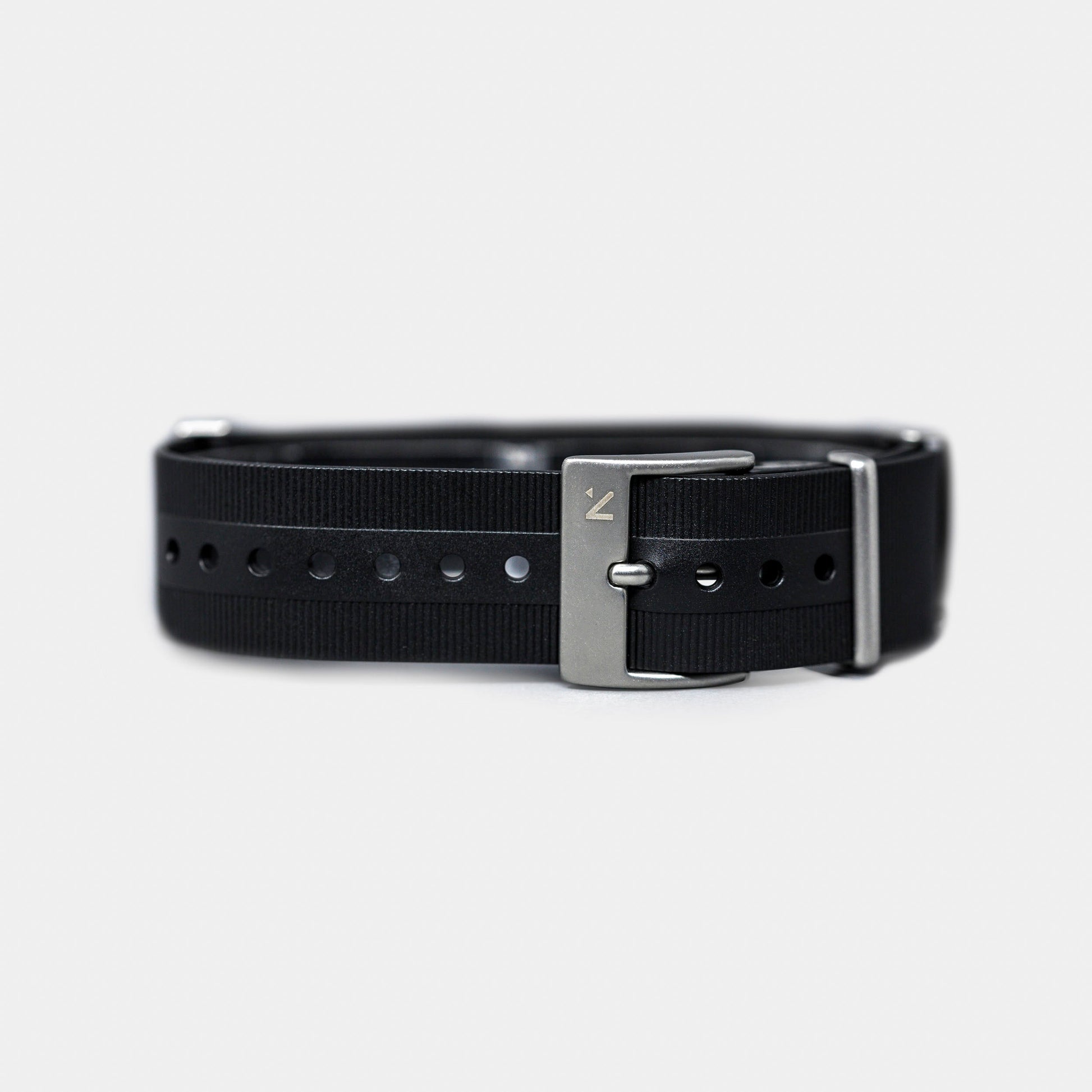 Black belt with silver buckle on a light gray background