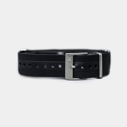 Black belt with silver buckle on a light gray background