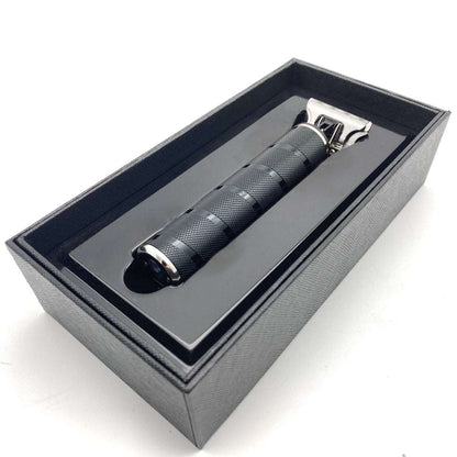 Black electric shaver in a gray box on a white background