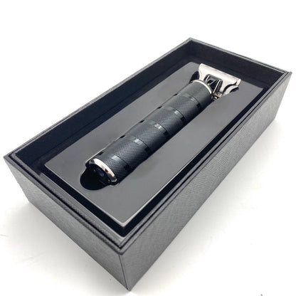 Black electric shaver in a gray box on a white background