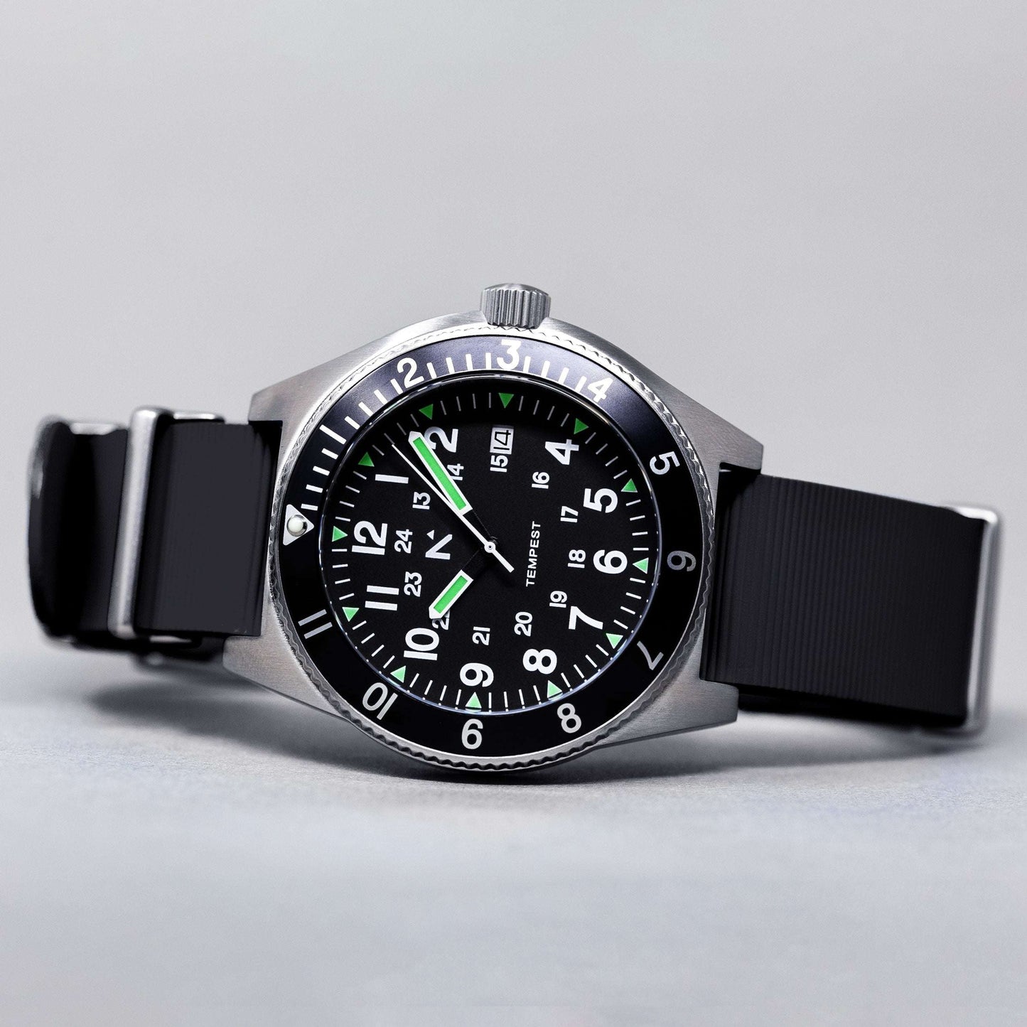 Wristwatch with black strap and green accents on a light gray background
