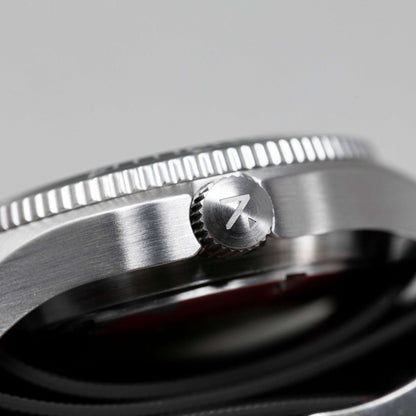 Close-up of a silver watch with a brand logo on a gray background