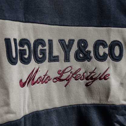 Text 'UGLY&CO Moto Lifestyle' on a fabric background