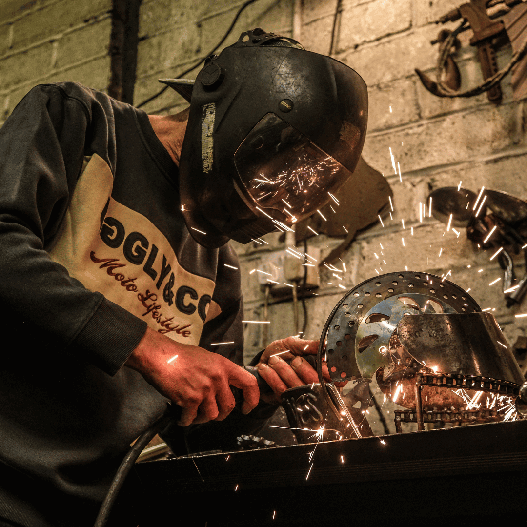 Person welding with sparks flying in a workshop setting