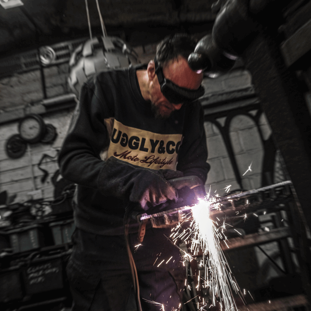 Person welding metal with sparks in a workshop setting